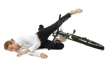 Young man falling off bicycle on white background
