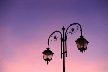 Fototapeta na wymiar Beautiful vintage street lamp against a bright sunrise sky