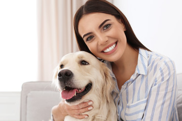 Young woman and her Golden Retriever dog in living room