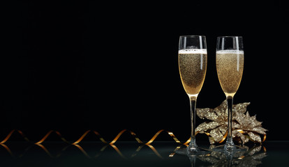 Two glasses of champagne ready to bring New Year on a black background.