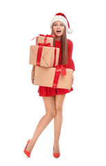 Emotional young woman in Santa hat with Christmas gifts on white background