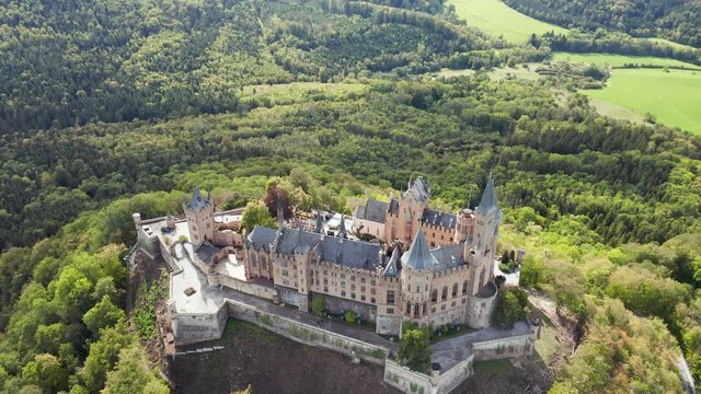 Aerial panorama of Burg Hohenzollern (Hohenzollern castle) with hills and villages surrounded by forests with beautiful foliage