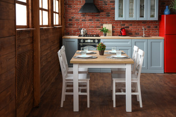 Stylish kitchen interior with dining table and chairs