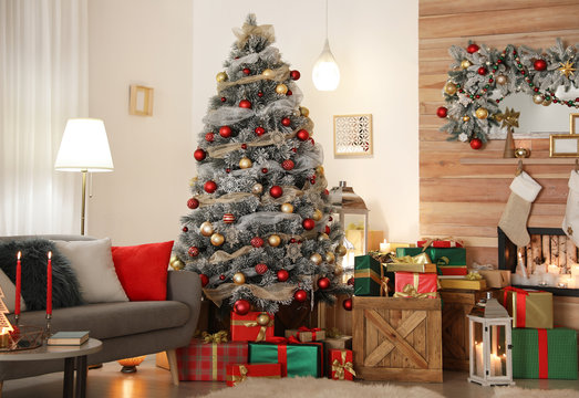 Beautiful living room interior with decorated Christmas tree and fireplace