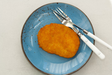Tasty vegetarian schnitzel on a blue plate. Plant based meat.