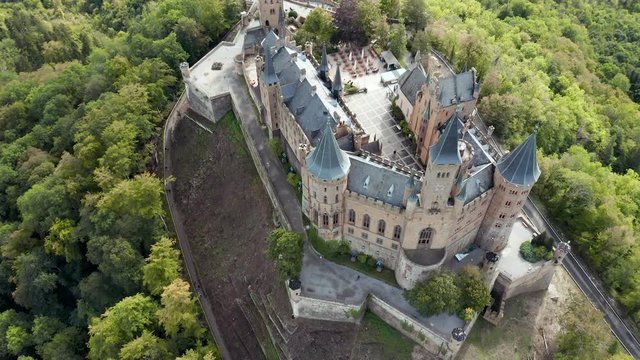 Aerial panorama of Burg Hohenzollern (Hohenzollern castle) with hills and villages surrounded by forests with beautiful foliage