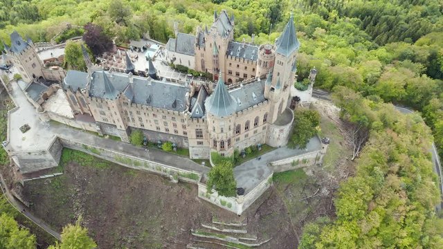 Aerial panorama of Burg Hohenzollern (Hohenzollern castle) with hills and villages surrounded by forests with beautiful foliage