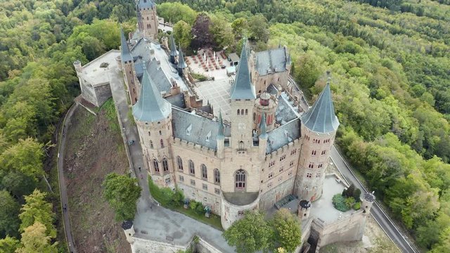 Aerial panorama of Burg Hohenzollern (Hohenzollern castle) with hills and villages surrounded by forests with beautiful foliage