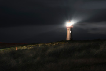 Lighthouse at night on Sylt island, at North sea,  on dunes