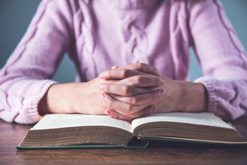 prayer woman hand on book