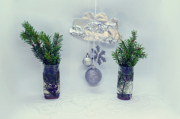 A beautiful handmade cloud, fir tree branches in glasses and frozen ice on a white background