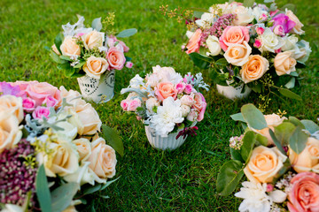 Five different wedding bouquets on a green grass.