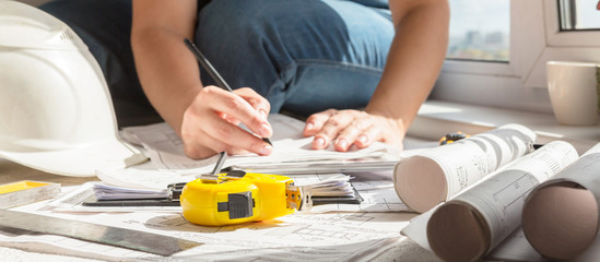 Fototapeta premium architect design working drawing sketch plans blueprints and making architectural construction model in architect studio,flat lay long banner