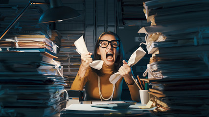 Angry stressed office worker overloaded with paperwork