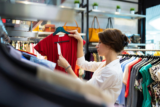 Attractive white woman looks at price tag at showroom