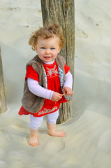 pretty little girl on vacation playing in the sand