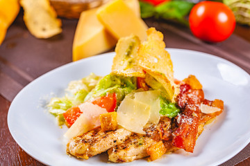 Caesar salad with bacon and chicken on white plate