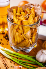 Snacks for beer. Fried potatoes in serving glass on wooden board