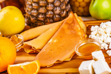 Pancakes and a variety of toppings on wooden board