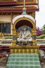 Ko Samui Island, Thailand - March 18, 2019: Wat Laem Suwannaram Chinese Buddhist Temple. Guru statue under Elaborately decorated gold and white stone baldachin.  Colors by flowers, incense, gemstones. © Klodien