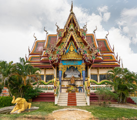 Fototapeta premium Ko Samui Island, Thailand - March 18, 2019: Wat Laem Suwannaram Chinese Buddhist Temple. Elaborately decorated full of colors front facade with several statues and paintings.