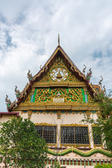 Fototapeta premium Ko Samui Island, Thailand - March 18, 2019: Wat Laem Suwannaram Chinese Buddhist Temple. Elaborately decorated full of colors south side facade under blue cloudscape and green foliage.