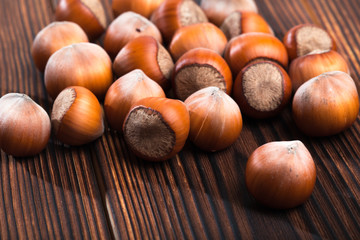 close up of hazelnuts on wooden table .
