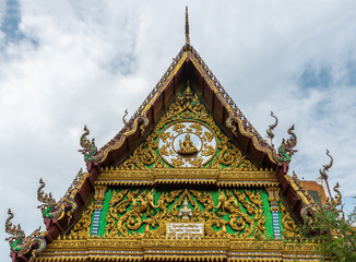 Fototapeta premium Ko Samui Island, Thailand - March 18, 2019: Wat Laem Suwannaram Chinese Buddhist Temple. Closeupp of Elaborately decorated full of colors south side gable under blue cloudscape.