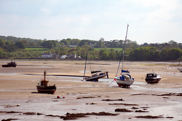 Wales – Anglesey island :  Low tide at Red Wharf bay.  Sand flats with several beached and stranded boats.  Picture may illustrate yaughting holidays in Wales.
