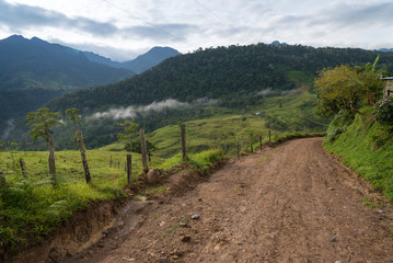 Fototapeta na wymiar Dirt road in countryside landscape with mountains in Colombia.