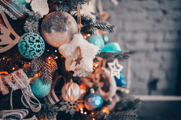 Details of a Christmas decorated tree in dark turquoise and orange colors. New Year and Christmas concept. Festive postcard