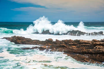Waves crashing wildly on the rocky shore at Storms River Mouth, Tsitsikamma National Park, South Africa