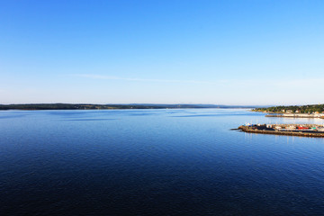 Panoramic view of harbor at North Sydney, Nova Scotia. Clear blue sky, calm water.