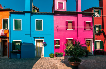 Fototapeta na wymiar picturesque buildings at a little street , houses of Burano with shadows in the evening