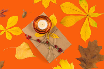 Autumn decorative gift set. The rectangular box is tied by a cord. Сandle with a burning candle on...