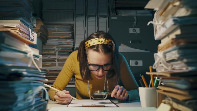 Businesswoman checking a document with a magnifier
