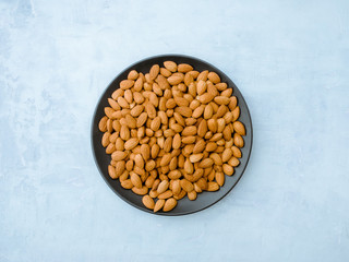 Almonds on light blue background, Top view.