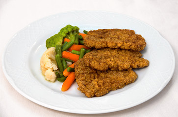 fried chops on a white plate with vegetables, healthy and tasty food. restaurant serving