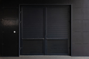 Black corrugated door - service entrance of building