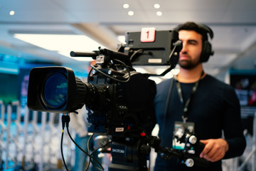 Professional cameraman with headphones with HD camcorder in live television