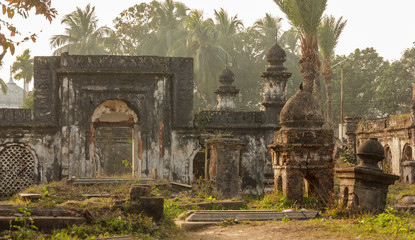 Obraz premium Murshidabad, West Bengal/India - January 17 2018: An ancient Islamic graveyard with old, ruined crypts and tombs of soldiers fallen in battle in the outskirts of Murshidabad.