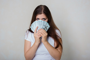 young, beautiful girl in a white T-shirt with money in hands