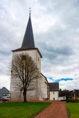Fototapeta na wymiar Church of St. Lambert in Manderfeld, Liege Province, Buellingen Municipality, Belgium under overcast April sky