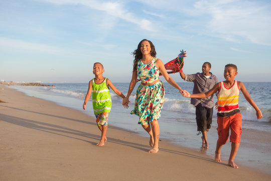 Happy Family At The Beach Flying A Kite