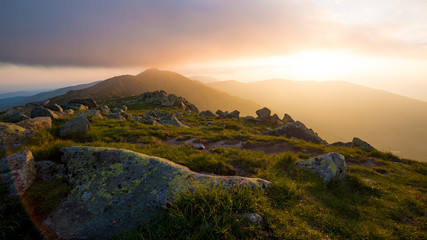 Fototapeta na wymiar Sunset At Low Tatras, Setting Sun Shines Through Clouds Over The Mountain
