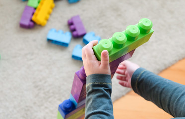 the child plays with the dice, puts one on top of the other