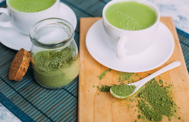  White cups with matcha and powder for its preparation.