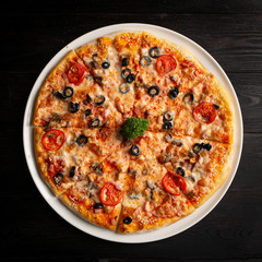 assorted pizza sliced into pieces with cheese, tomato and olives