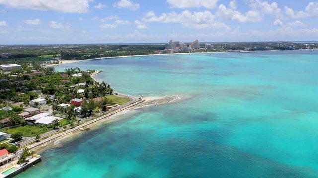 Aerial: Looking Over Tropical Water Towards Waterfront Homes, Scenic Road and Beach Hotels - Nassau, Bahamas