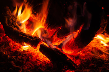 Fading cozy bonfire with calving bright coals.